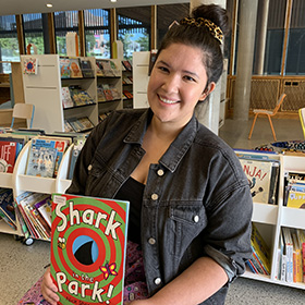 Librarian holding up a book Shark in the Park by Nick Sharratt